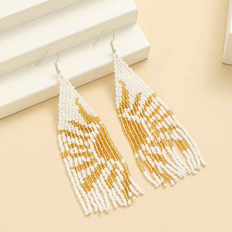Hand‑woven bohemian rice bead earrings in white and gold with geometric dangle design