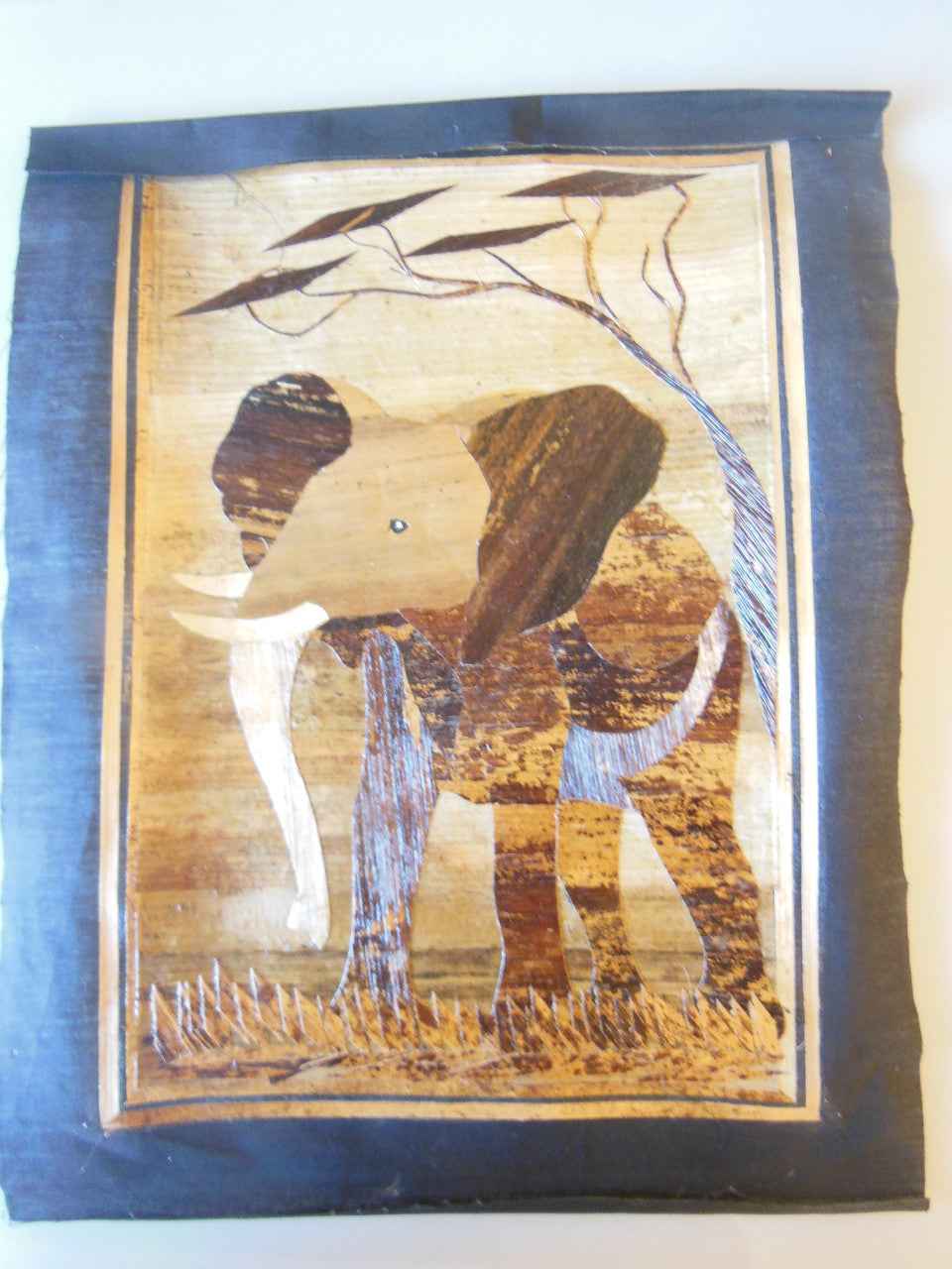 Tanzania- Intricately cut wood elephant on Fabric.  Framed.